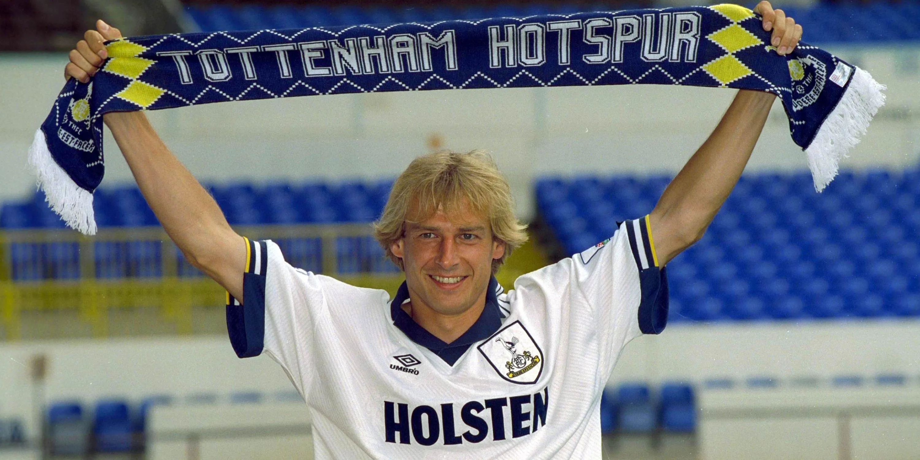 Jurgen Klinsmann giơ cao chiếc khăn Tottenham sau khi ký hợp đồng với câu lạc bộ